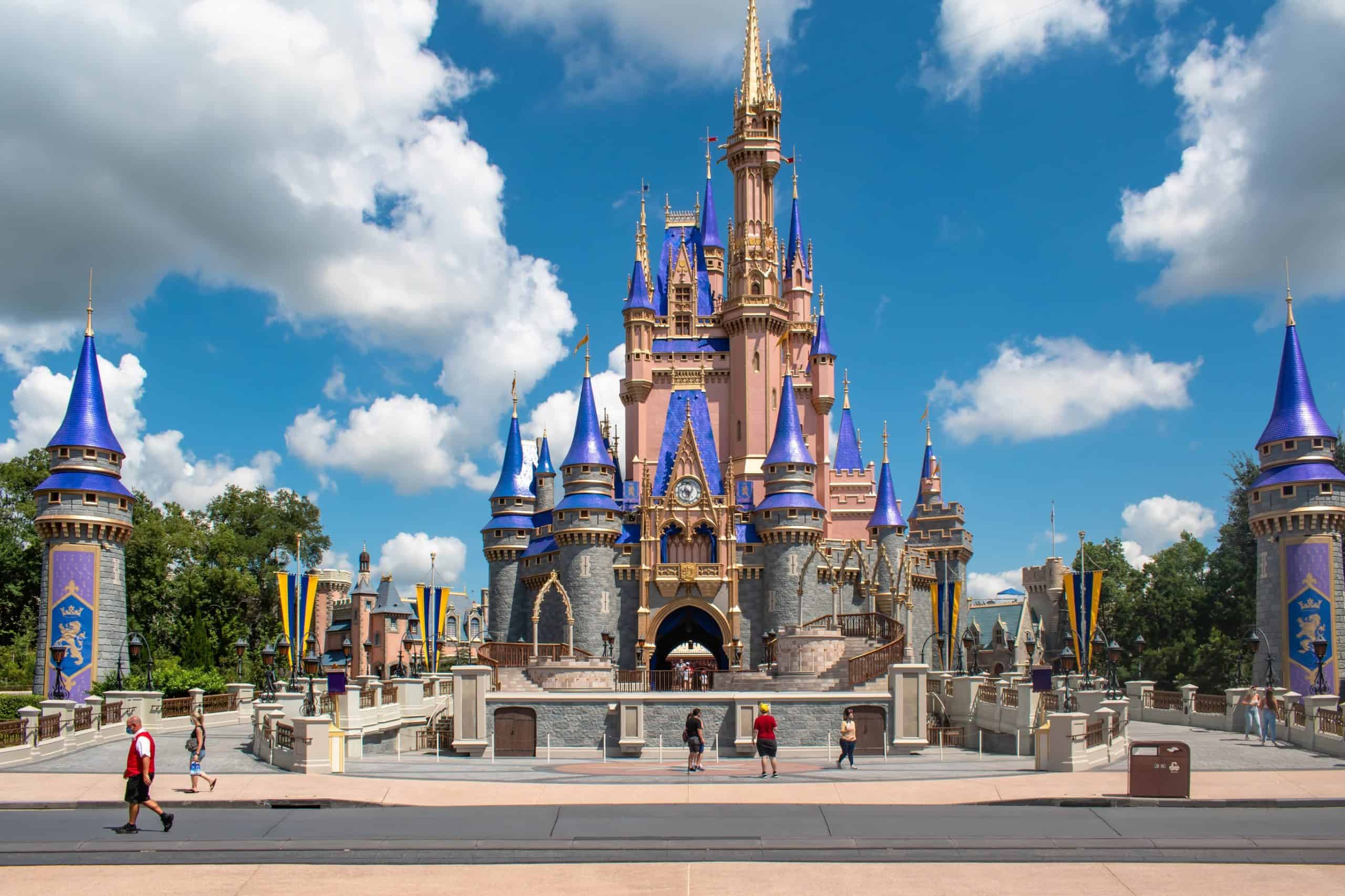 Cinderella Castle at Magic Kingdom with few people and blue sky and clouds in background