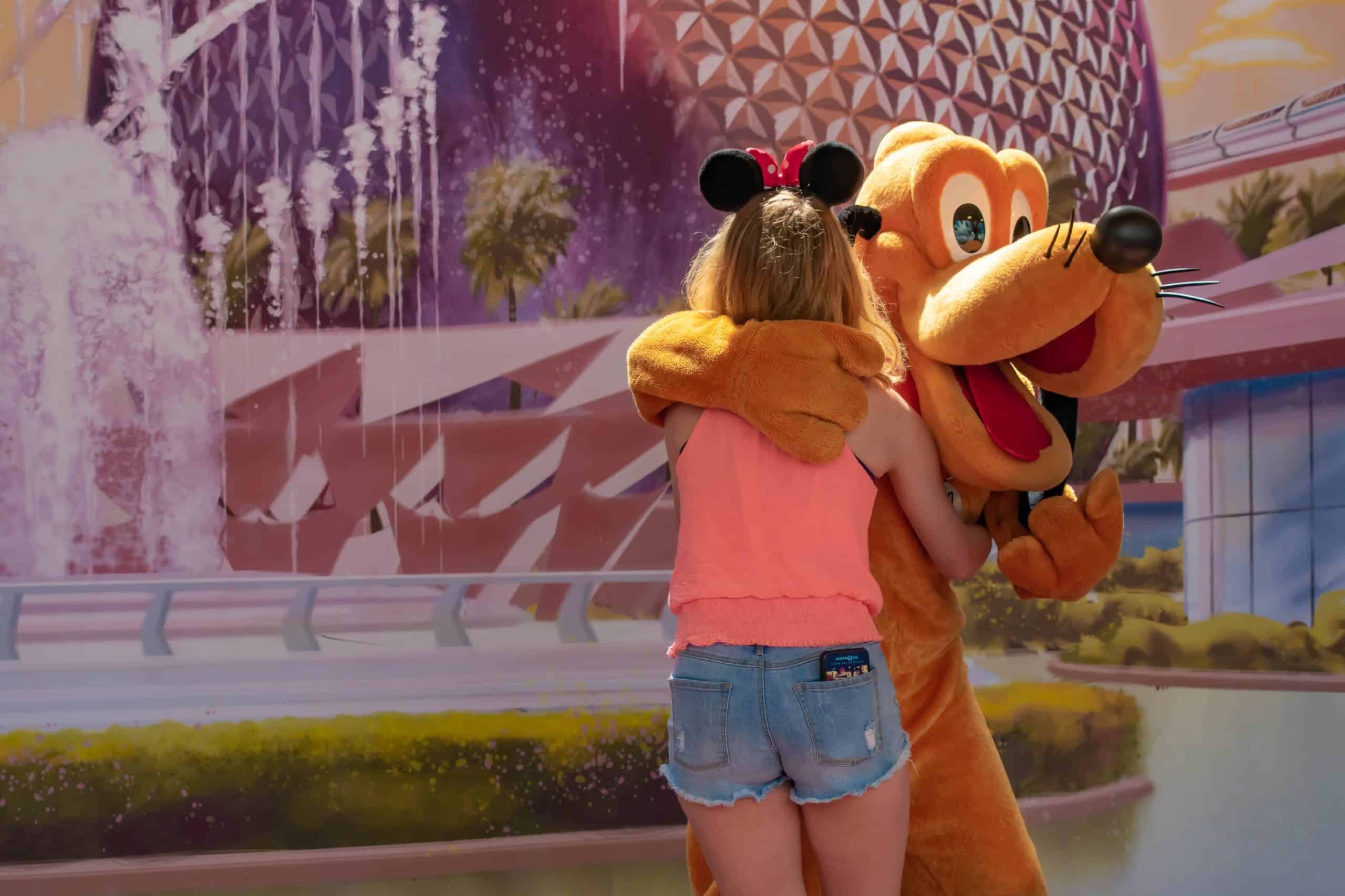 Woman in Minnie Ears hugging Pluto at EPCOT