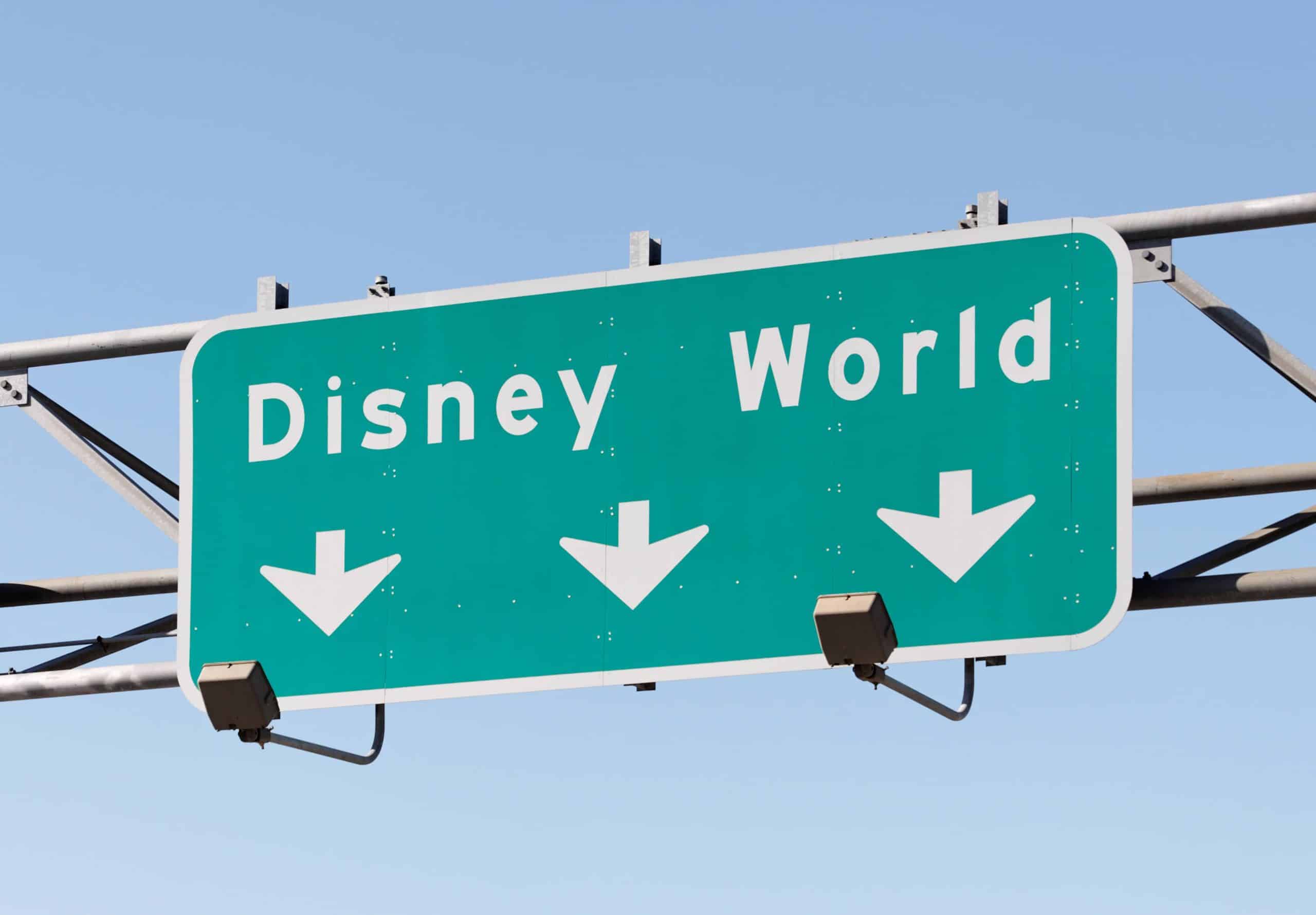 Road sign showing arrows to Disney World