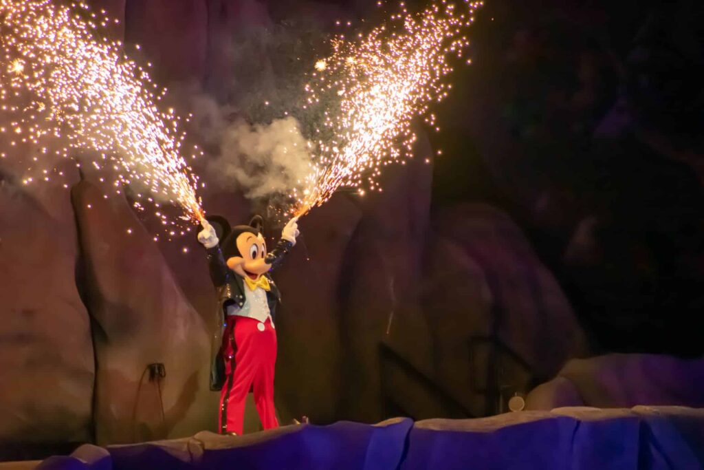 Picture of Mickey Mouse in classic outfit with fireworks shooting out of fingers at the Fantasmic show at Hollywood Studios