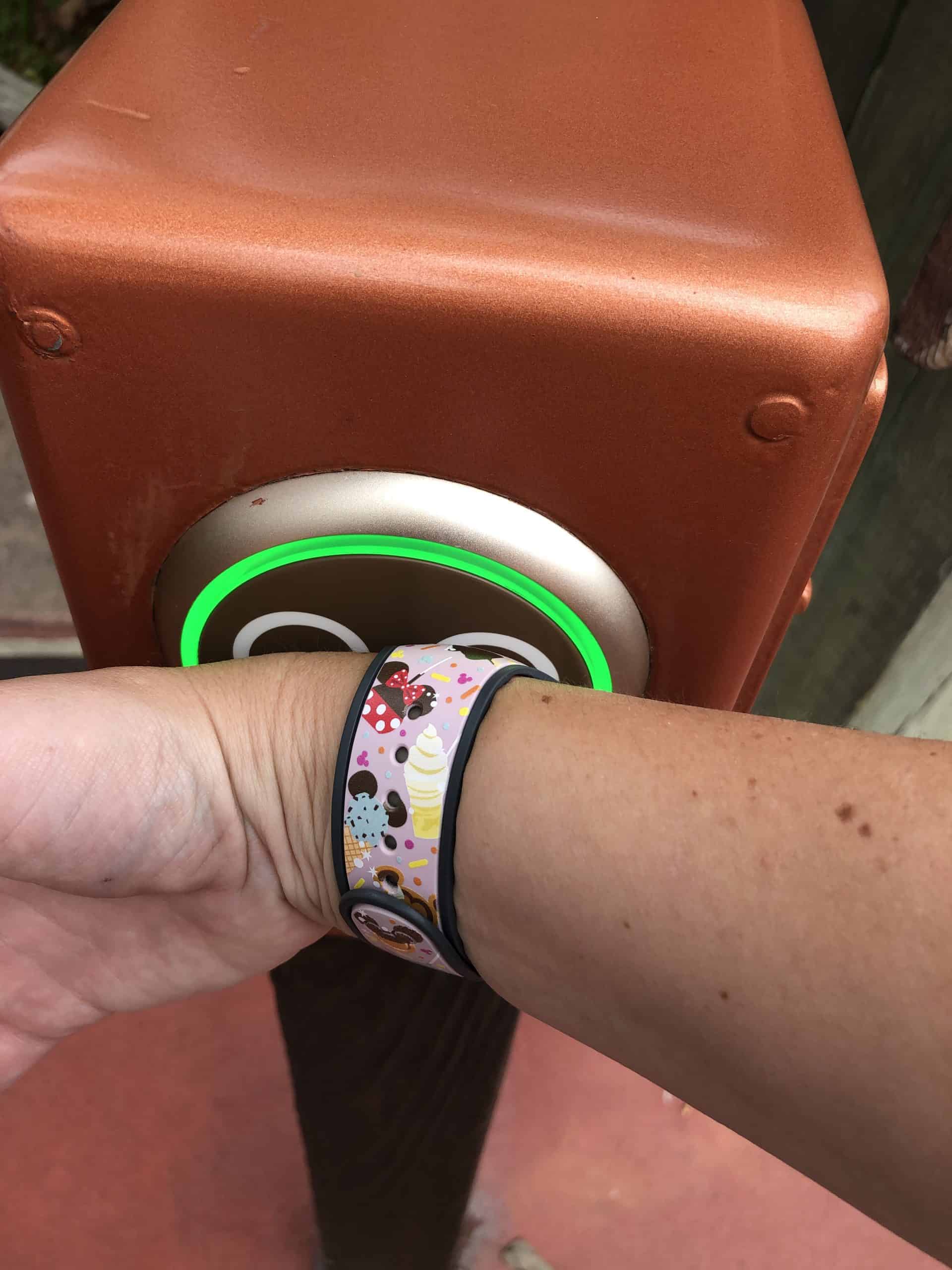 Scanning into the Disney World turnstile with a pink snack MagicBand