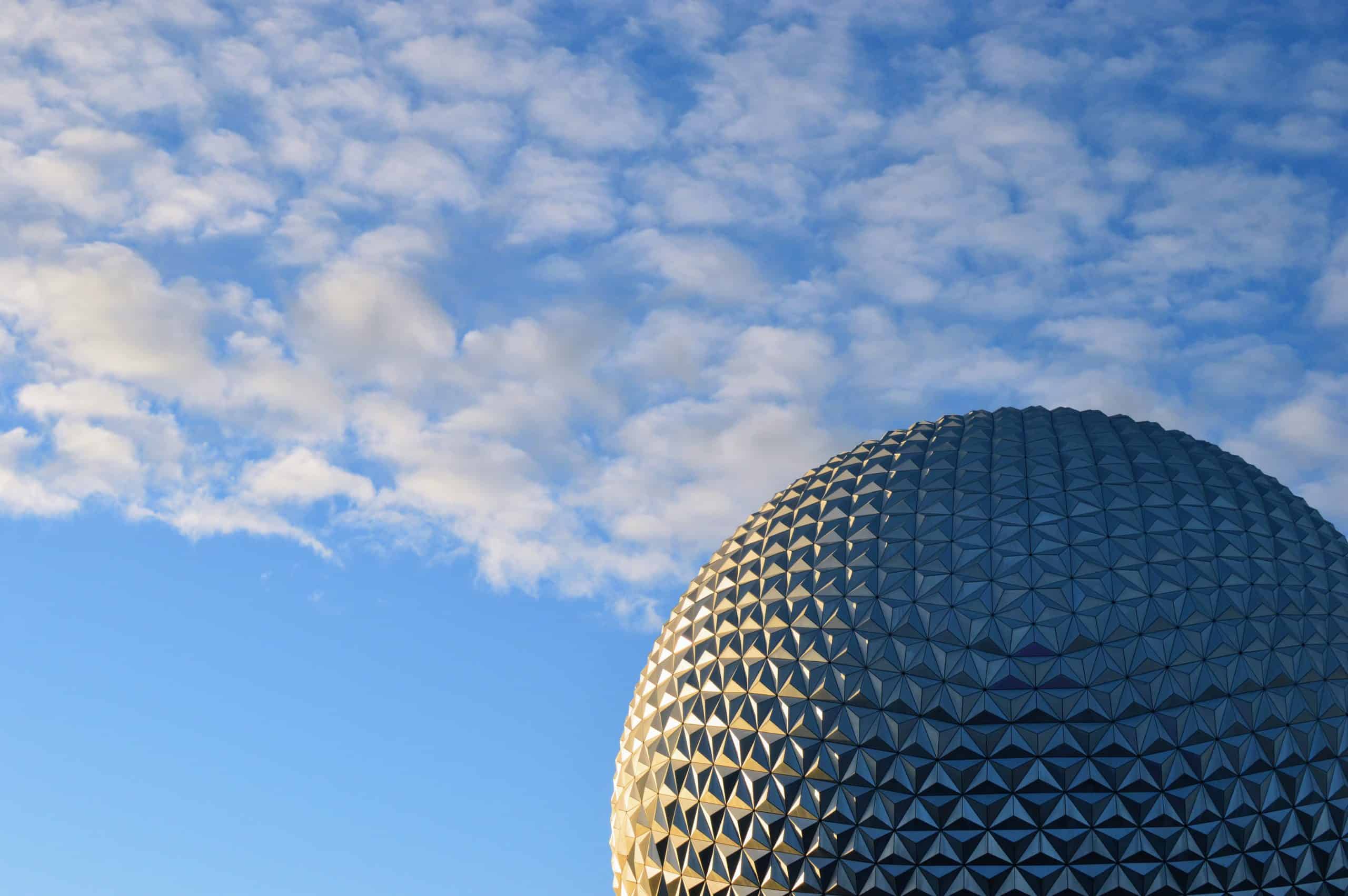 Photo of blue sky with clouds and EPCOT ball Spaceship Earth in background