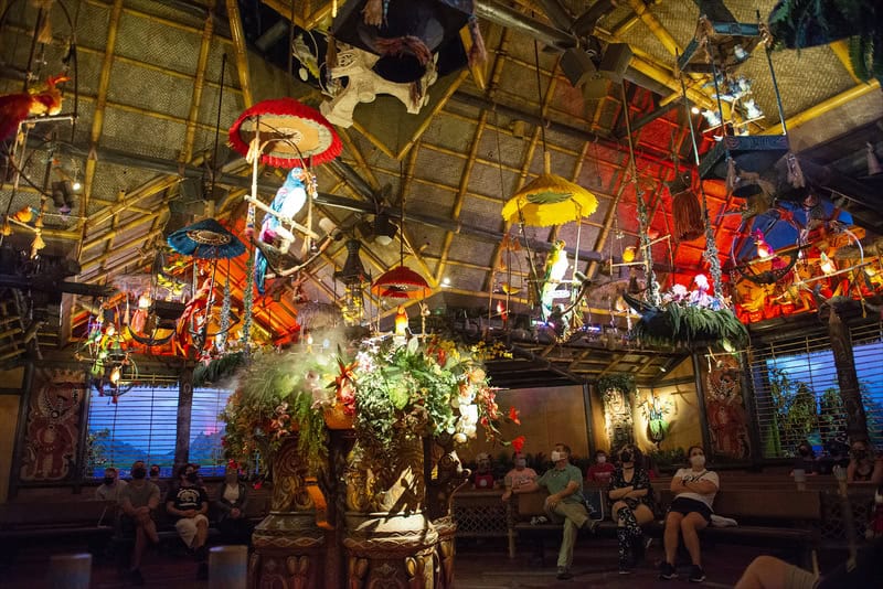 Inside of Enchanted Tiki Room with straw hut, birds and umbrella
