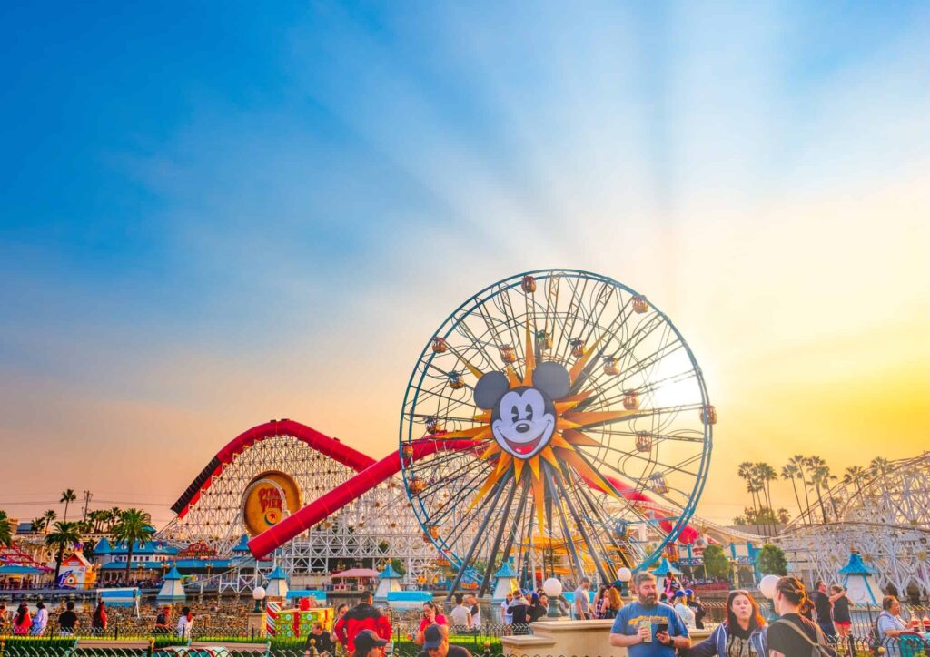 Sunburst on clear blue day with Mickey ferris wheel and Incredicoaster in background