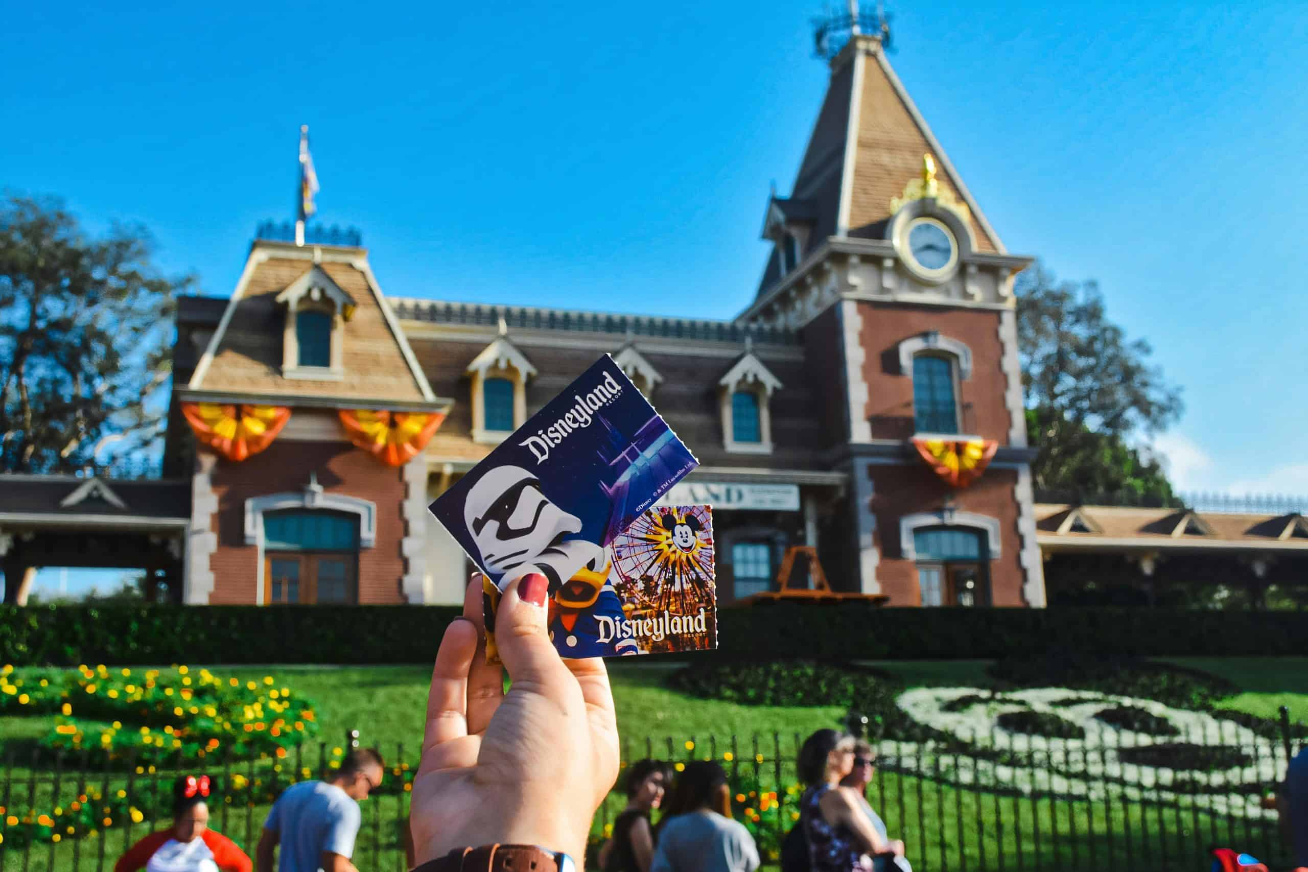 Person holding Disneyland ticket at the front of the park