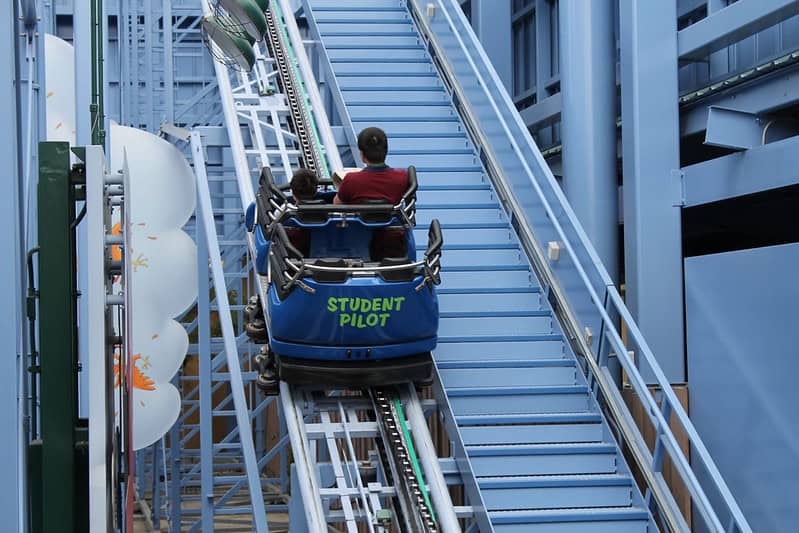 Small coaster car with two people going up in Goofy's Sky School ride