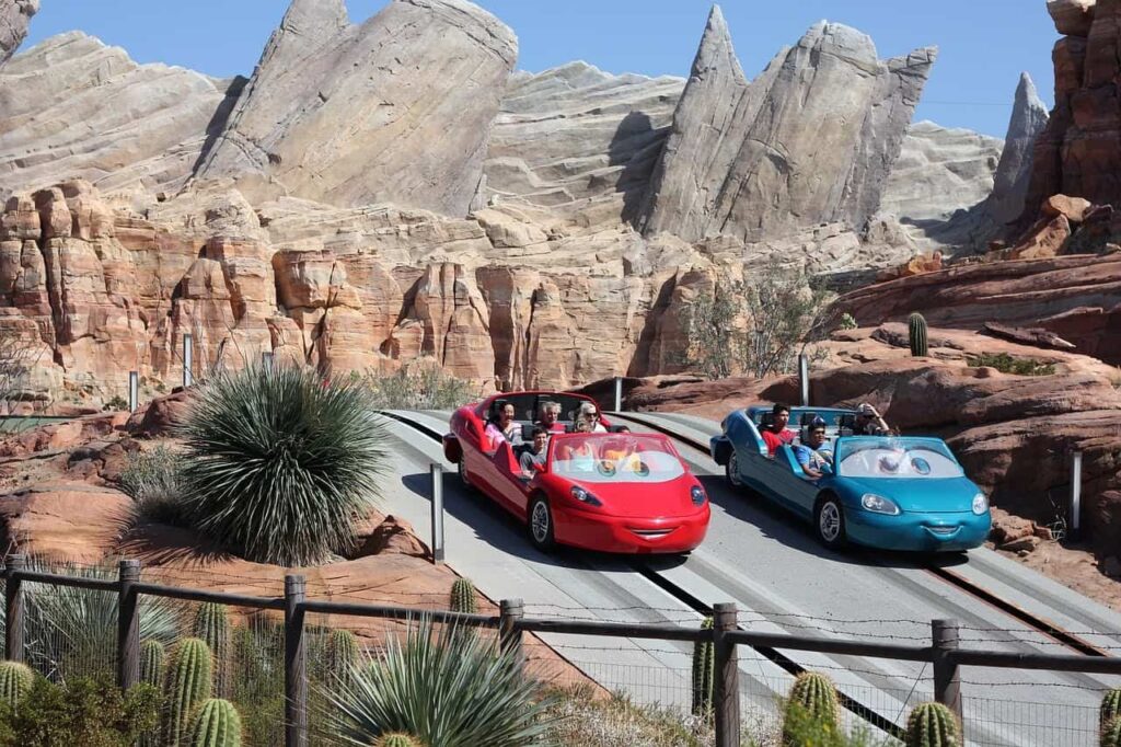 Red and blue cars racing side by side at Radiator Springs Racers