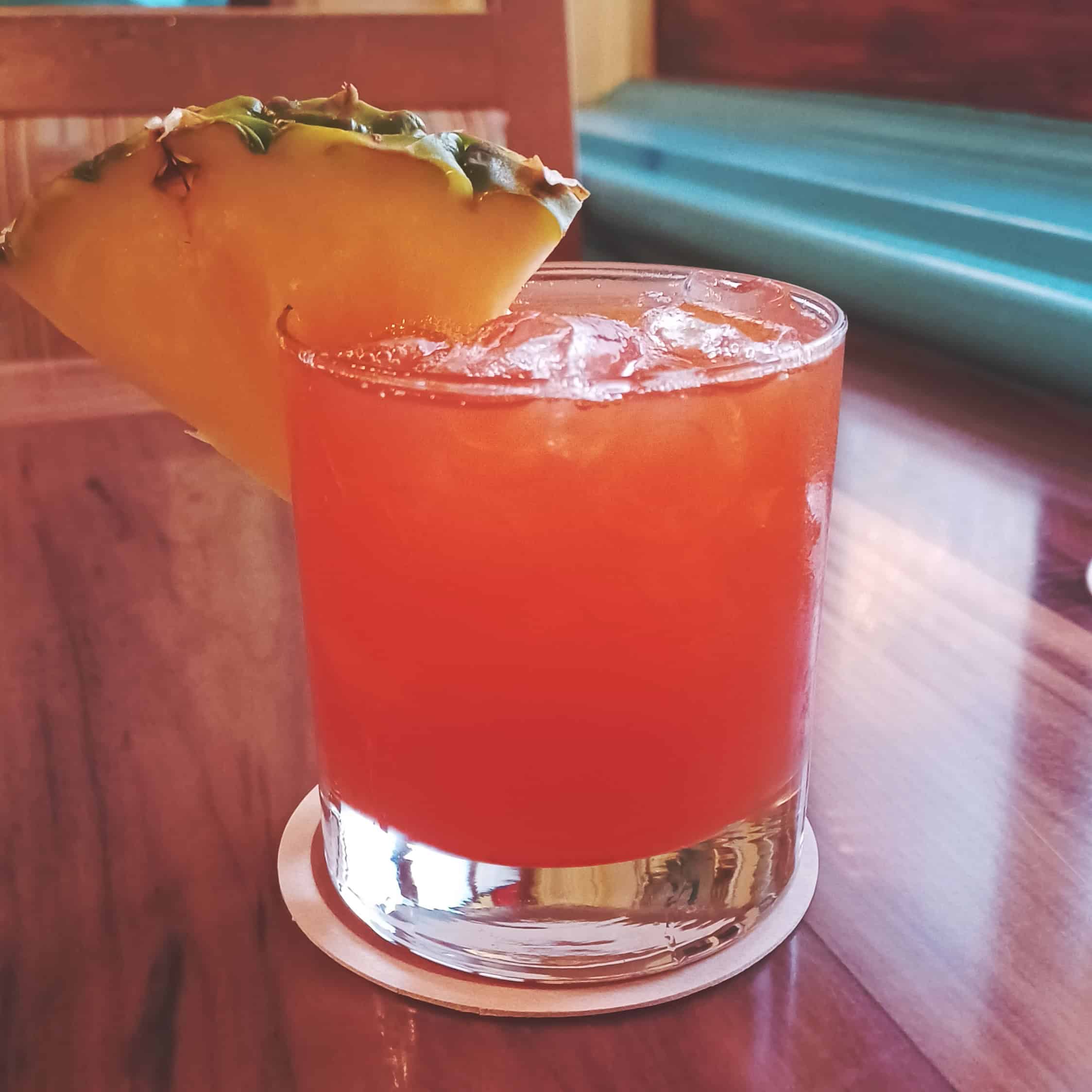 Jungle Bird pink cocktail with pineapple wedge garnish at Skipper Canteen in Magic Kingdom