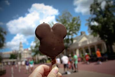Mickey ice cream bar with blue sky and clouds in background